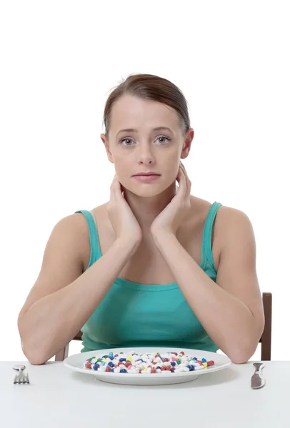 錠剤がいっぱい皿を食べようとして タブレットで座っている女性 — ストック写真