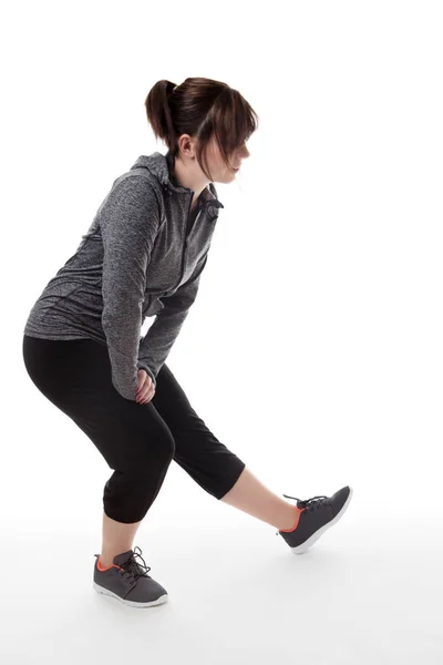 Femme de remise en forme tiré dans le sudio étirant une jambe — Photo