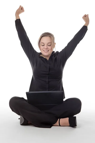 快乐的商业妇女坐在地板上使用笔记本电脑与她的手臂在空气中的喜悦 — 图库照片