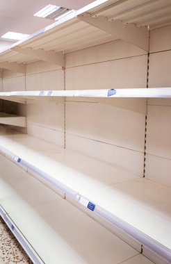 Dükkandaki boş rafta geçici olarak stokları bitti yazan bir tabela var.