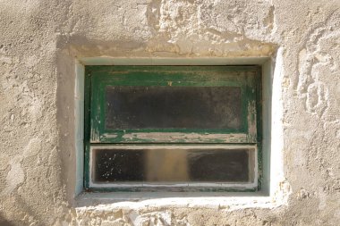 Eski dokulu beton bir binanın ahşap penceresi.