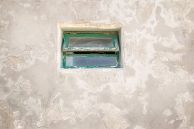 Eski dokulu beton bir binanın ahşap penceresi.