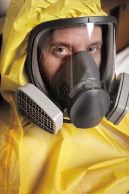 Kendini izole eden bir kişinin portresi. Koruyucu giysi ve maske takıyor.