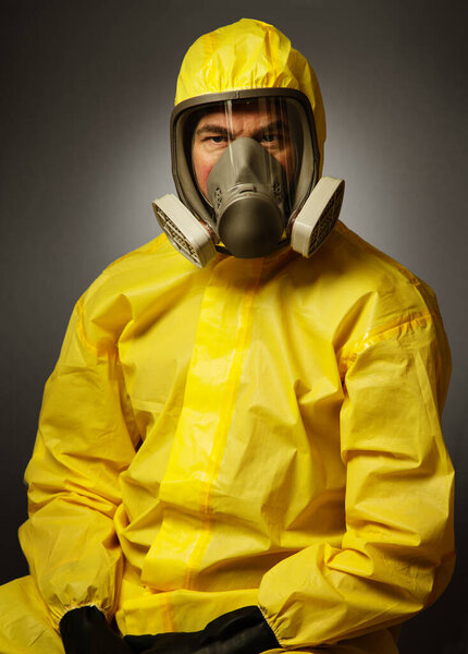 portairt of a single man wearing a protective hazmat suitshot in the studio on a background