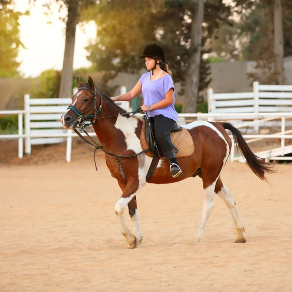 Chica joven recibiendo una lección de equitación — Foto de Stock
