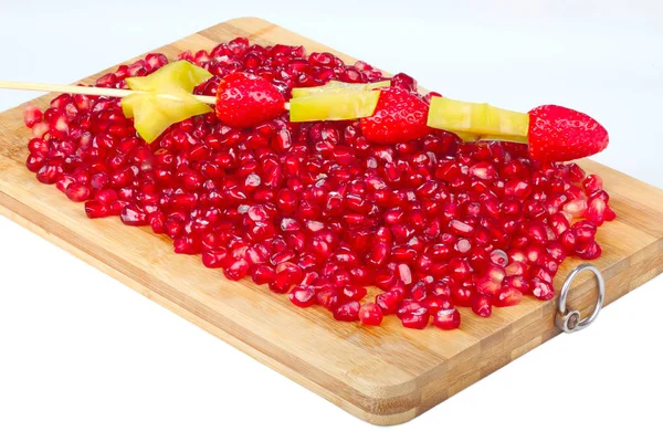 Graan van rode granaatappel op houten bord — Stockfoto