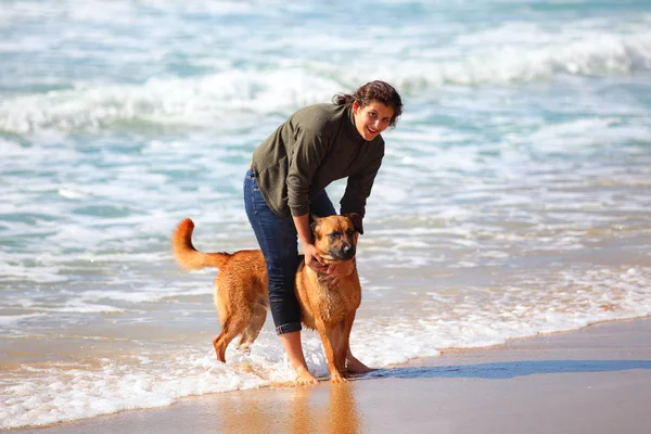 Adolescente menina com seu cão na praia . — Fotografia de Stock
