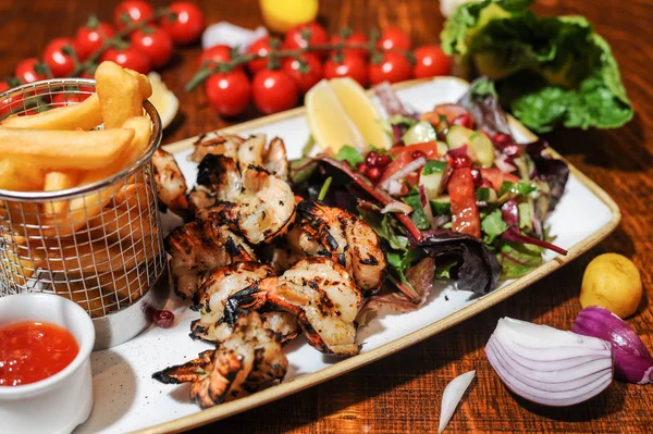 Grilled chicken wings with vegetables and french fries — Stock Photo, Image