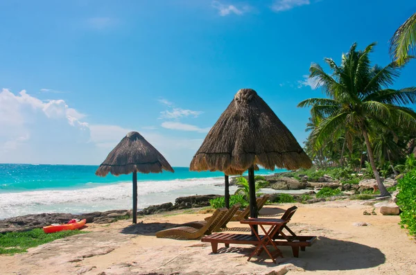 Liegestühle und Sonnenschirm an einem wunderschönen tropischen Strand — Stockfoto