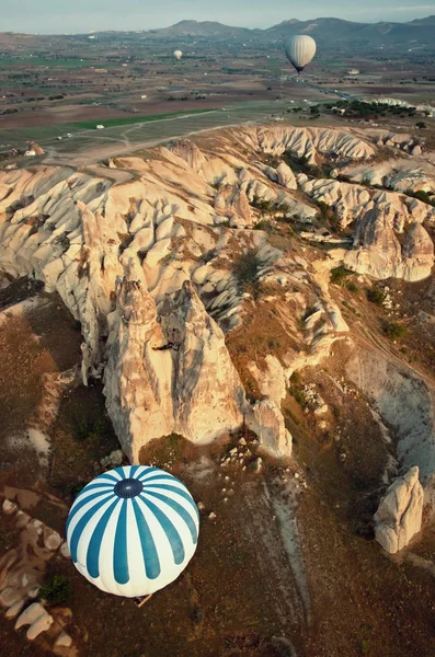Horkovzdušné balóny nad horskou krajinou v Kappadokie — Stock fotografie