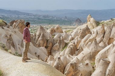 Hiker enjoying wonderful mountain landscape carved in volcanic tuff by erosion in Cappadocia, Turkey clipart