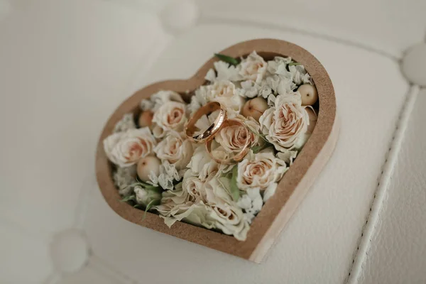 Όμορφη γαμήλια δαχτυλίδια βρίσκονται στο φόντο της ένα μπουκέτο λουλούδια — Φωτογραφία Αρχείου