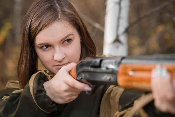 Ritratto di una bella giovane cacciatrice in abiti mimetici nella foresta decidua in natura con una pistola — Foto Stock