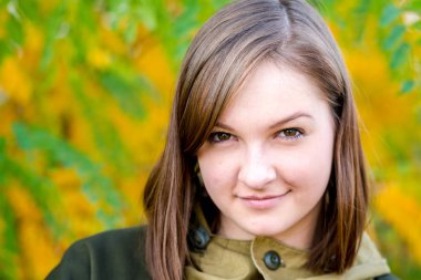 yaprak döken orman silahla doğada kamuflaj giysili bir güzel genç kız avcı portresi