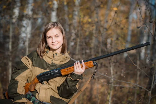 Портрет красивой молодой девушки-охотницы в камуфляжной одежде в лиственном лесу на природе с пистолетом — стоковое фото