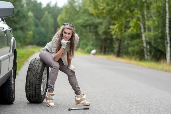 Portrét krásné mladé dívky, která opravuje rozbité auto — Stock fotografie