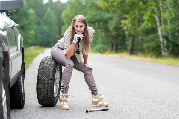 Portrét krásné mladé dívky, která opravuje rozbité auto — Stock fotografie