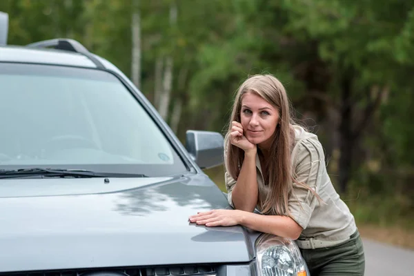 Retrato de uma bela jovem que está reparando um carro quebrado — Fotografia de Stock