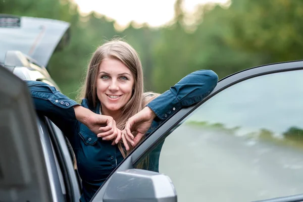 Portrét krásné mladé dívky, která opravuje rozbité auto — Stock fotografie