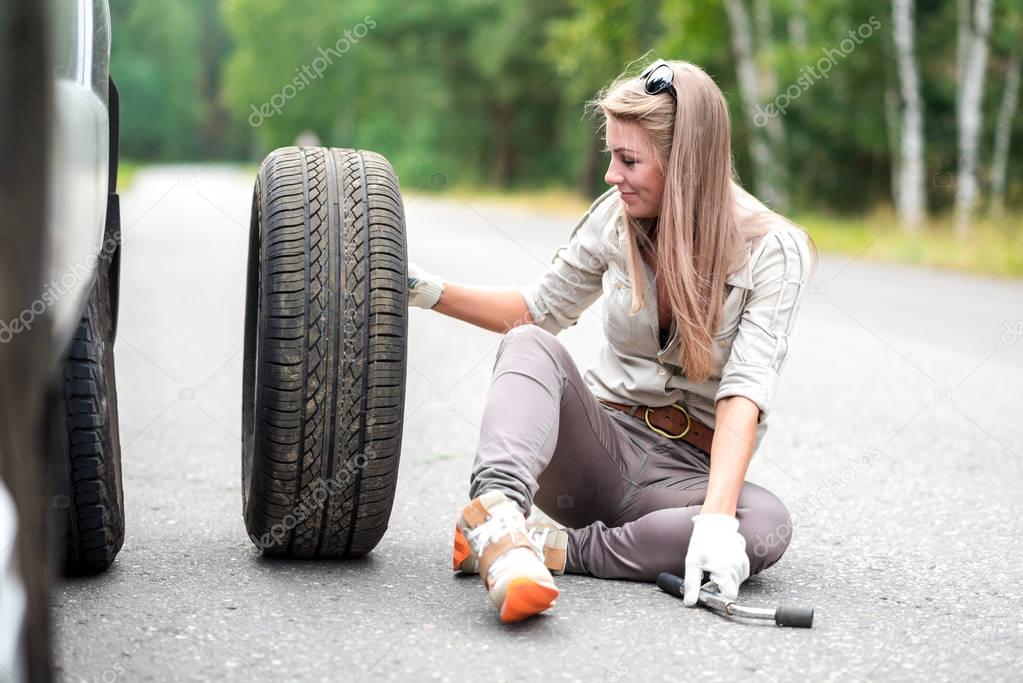 portrait of a beautiful young girl who is repairing a broken car