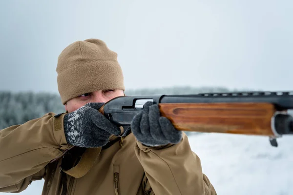 Hombre cazador vestido con ropa de camuflaje de pie en el invierno — Foto de Stock