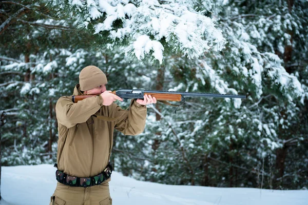 Hombre cazador vestido con ropa de camuflaje en el pino de invierno fo — Foto de Stock