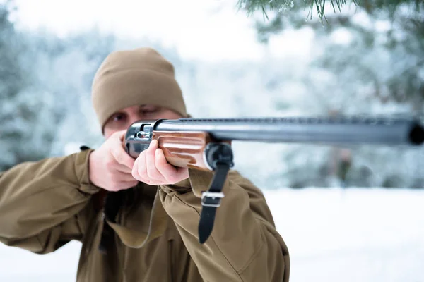 Hombre cazador vestido con ropa de camuflaje en el pino de invierno fo — Foto de Stock