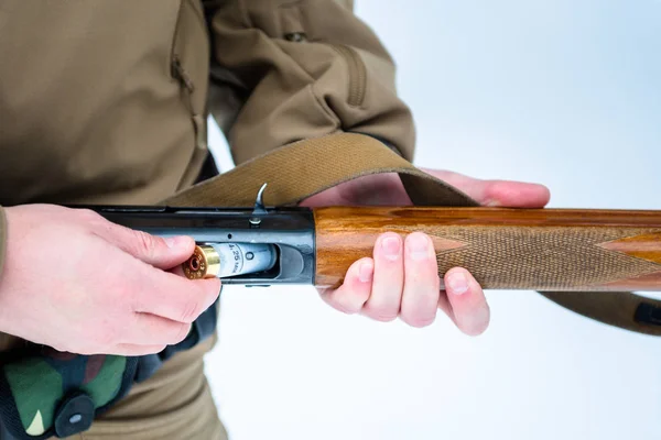 Macho manos cazador insertado cartucho 12 calibre rifle en un respaldo — Foto de Stock