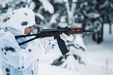 otomatik tüfek bir terörist beyaz kamuflaj tutar.