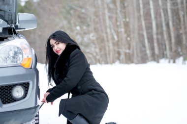 Hata araba kışın. Genç güzel kız t onarmaya çalışmak