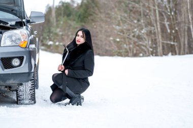 Hata araba kışın. Genç güzel kız t onarmaya çalışmak
