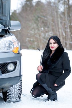 Hata araba kışın. Genç güzel kız t onarmaya çalışmak