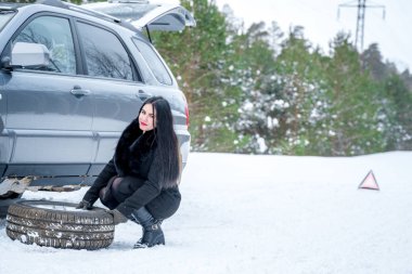 Hata araba kışın. Genç güzel kız t onarmaya çalışmak