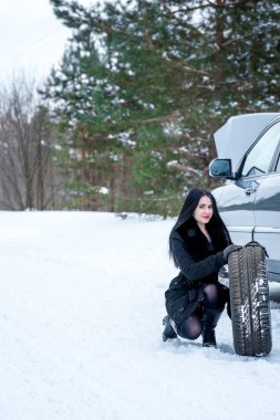 Hata araba kışın. Genç güzel kız t onarmaya çalışmak