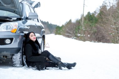 Hata araba kışın. Genç güzel kız t onarmaya çalışmak