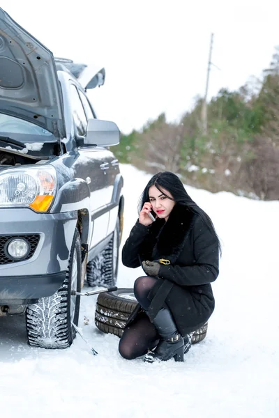 Winter car breakdown - young beautiful woman call for help, road