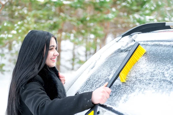 Mulher limpeza carro pára-brisa de neve inverno feliz jovem raspador — Fotografia de Stock