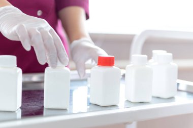 bir laboratuvar biyolog kollarında ilaç kabı