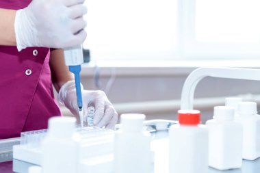 bir laboratuvar biyolog kollarında ilaç kabı