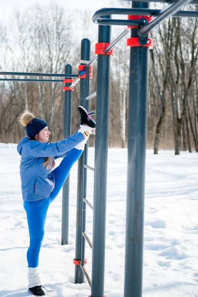 Güzel genç kız germe, fitness spor alanı üzerinde yapıyor