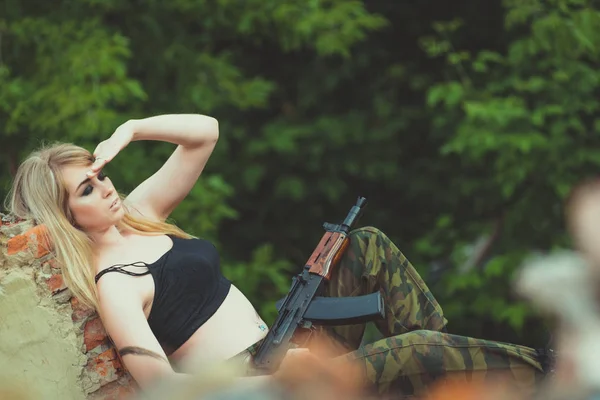 Retrato de uma linda garota em camuflagem com uma arma em seu han — Fotografia de Stock