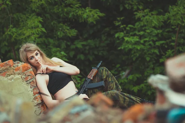 Porträtt av en vacker flicka i kamouflage med en pistol i hennes han — Stockfoto