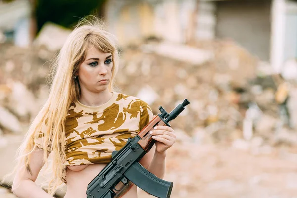 Portret van een mooi meisje in het geel camouflage en een cap met — Stockfoto