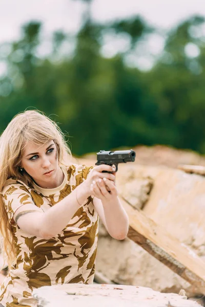 Retrato de uma menina bonita em camuflagem amarela e um boné com — Fotografia de Stock