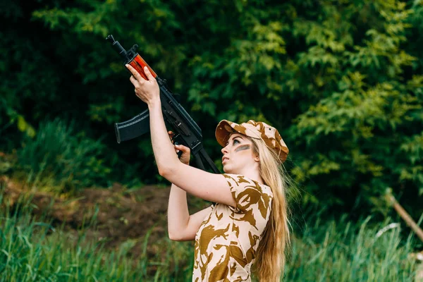 Portret van een mooi meisje in het geel camouflage en een cap met — Stockfoto