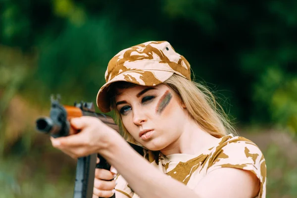 Portret van een mooi meisje in het geel camouflage en een cap met — Stockfoto