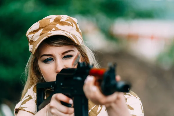 Retrato de una hermosa chica en camuflaje amarillo y una gorra con — Foto de Stock