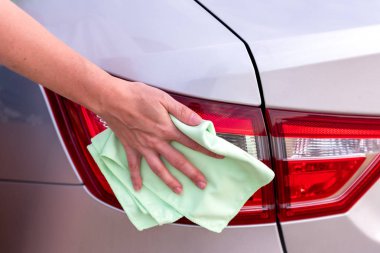 Bir el ile bir mikrofiber bez arka lambalar, temizler bir 