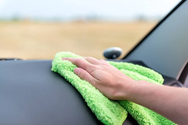 A female hand wipes the panel of a modern auto rag with a microf