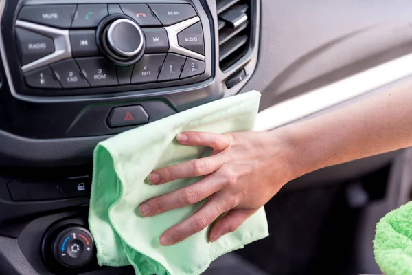 A female hand with a microfibre cloth cleans the panel of a mode